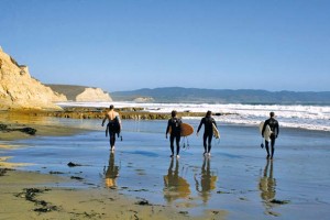 Surfers walking down Drakes Beach. Photo (c) Monda Rafla.