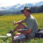 John Muir Laws in the field with pen and paper.