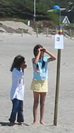kids looking at solar system model on beach