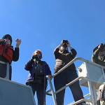Four people with binoculars