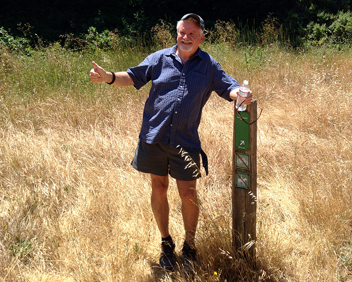 David Hansen gives a thumbs-up at a marker for the trail named after him in Roy's Redwoods Open Space Preserve. (Photo courtesy David Hansen)