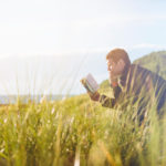 man reading in meadow
